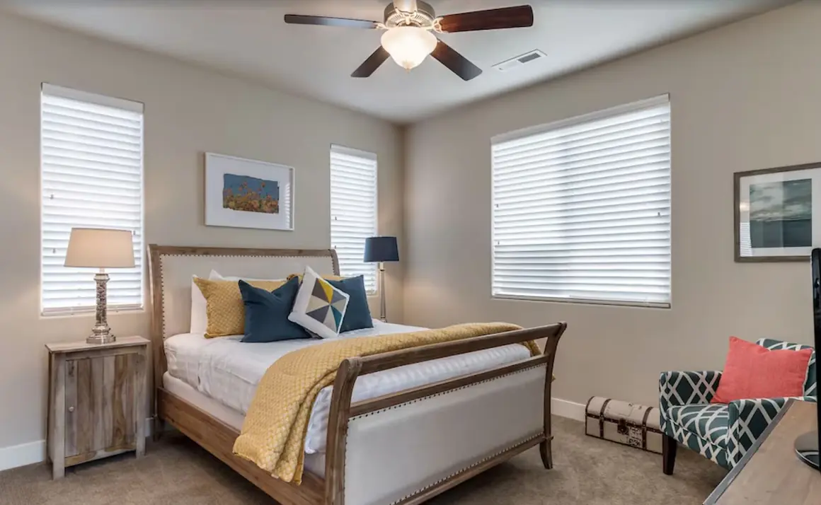 Casita bedroom with an upholstered sleigh bed and yellow throw