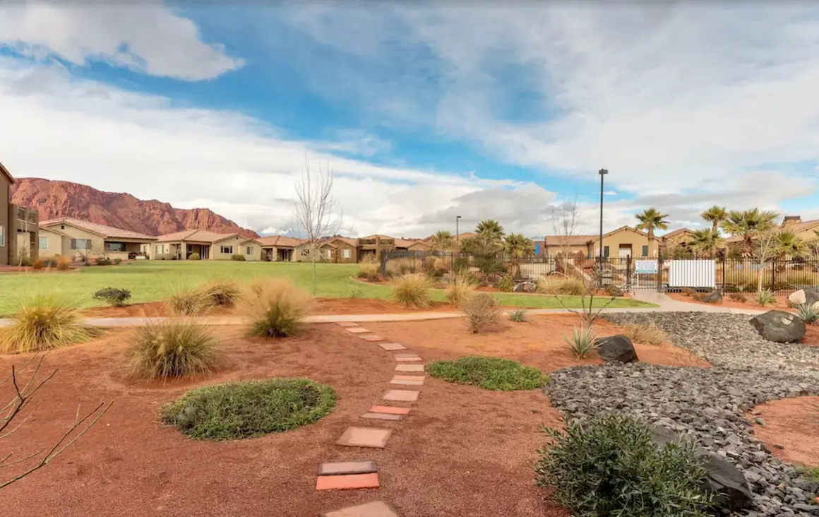 Desert garden path through Paradise Village toward red cliffs