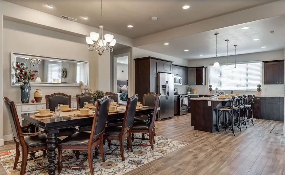 Dining table set for dinner with the kitchen island behind