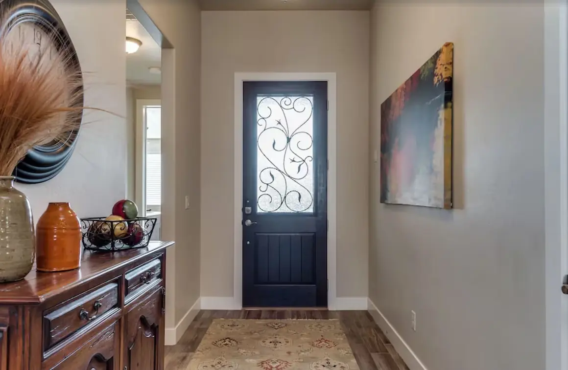 Entry hall with a wrought-iron glass front door