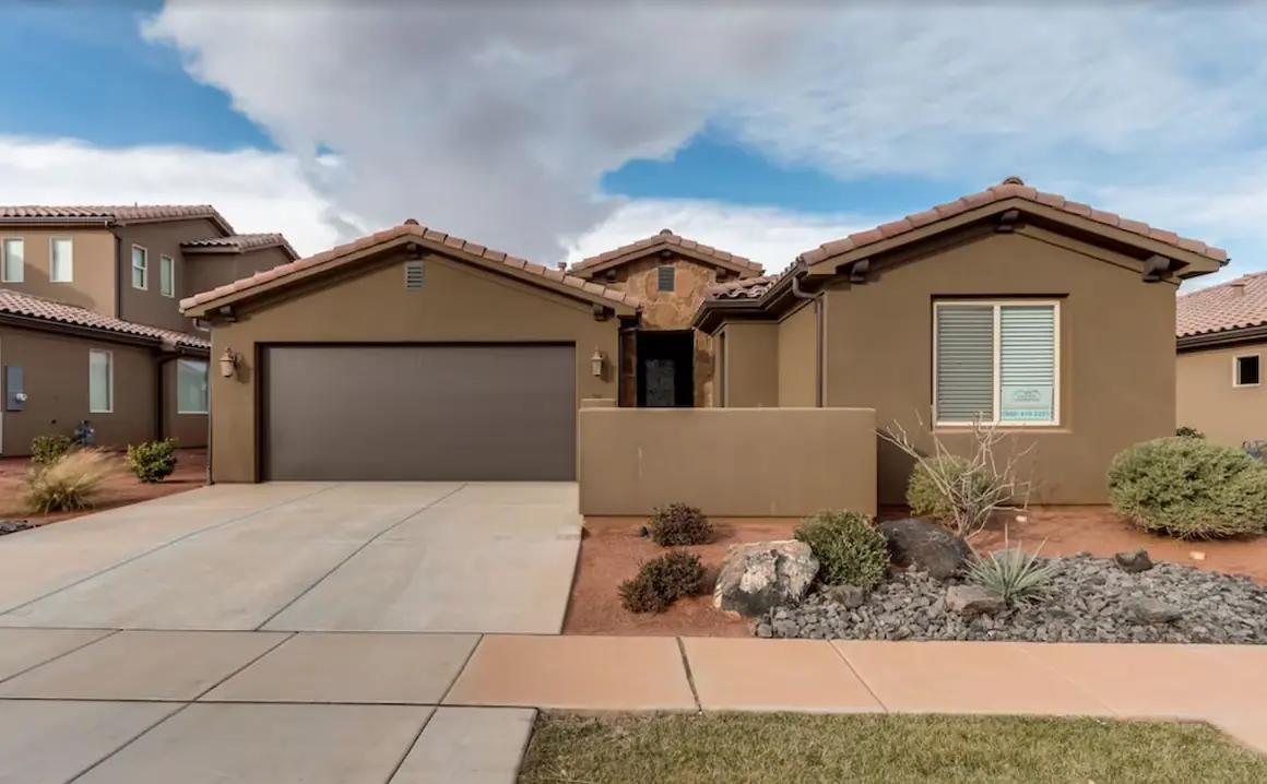Front of the single-level stucco house with a two-car garage