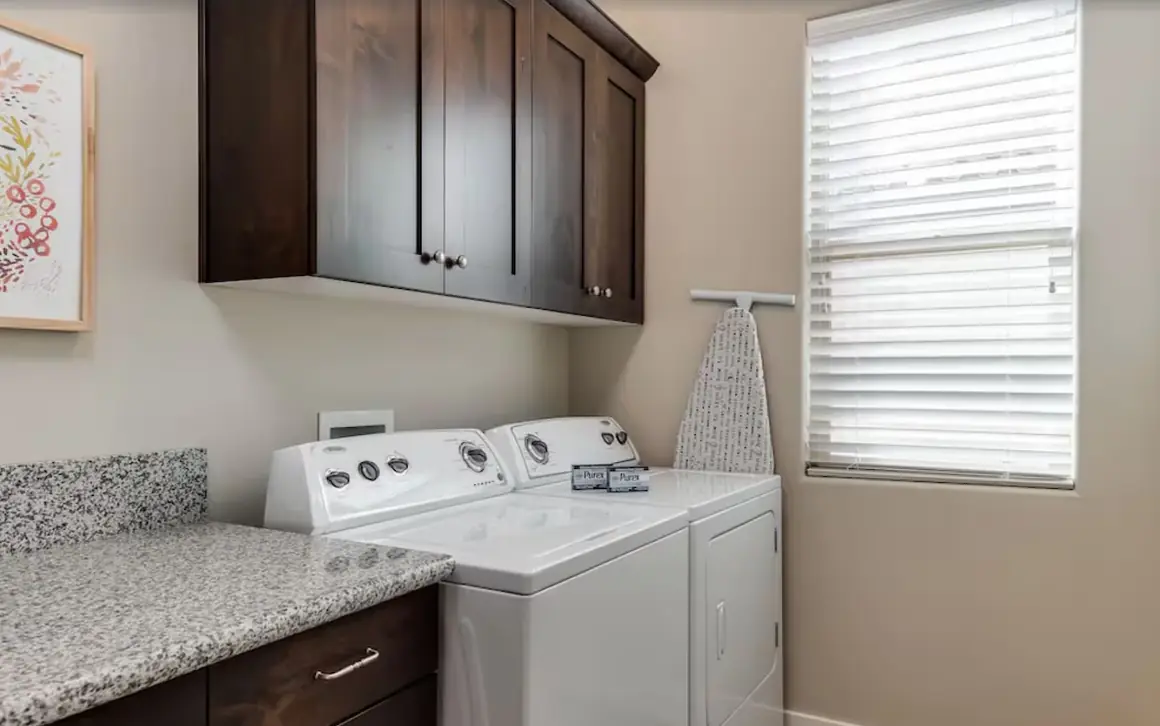 Laundry room with a full washer, dryer and ironing board