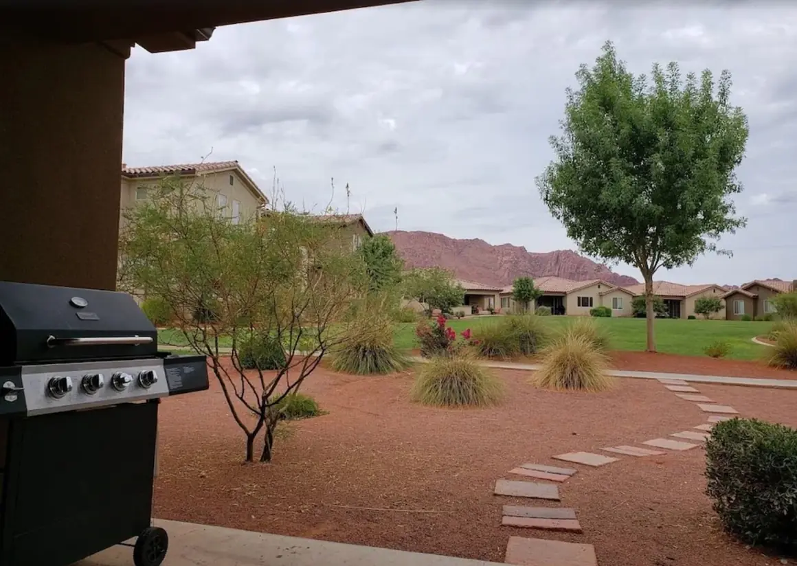 View from the patio past the grill to the lawn and red cliffs
