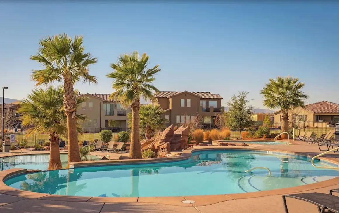 Resort pool and hot tub framed by palm trees